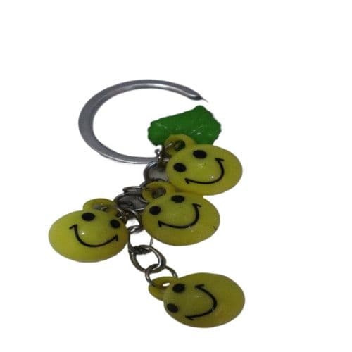 Bright Yellow Smiley Face Ball Keychain with Green Leaf Accent - Durable Plastic Design.